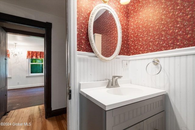 bathroom featuring vanity, ornamental molding, and wood-type flooring