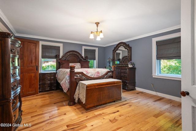 bedroom featuring ornamental molding, light hardwood / wood-style flooring, and a notable chandelier