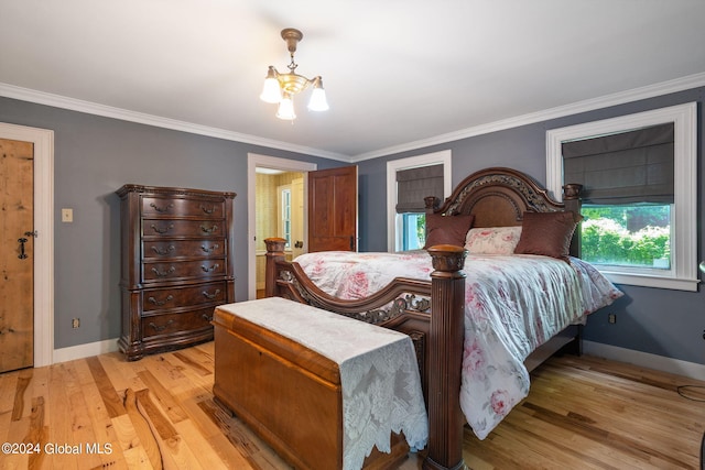 bedroom with ornamental molding, a notable chandelier, and light hardwood / wood-style flooring