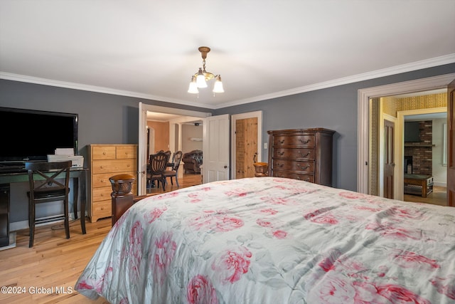 bedroom featuring light wood-type flooring, crown molding, and an inviting chandelier