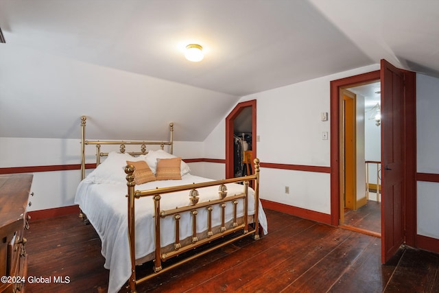 bedroom with a closet, dark hardwood / wood-style flooring, and vaulted ceiling