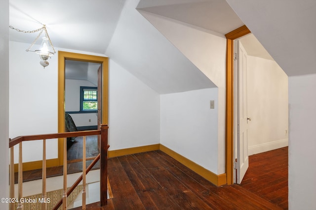 additional living space featuring dark wood-type flooring and lofted ceiling