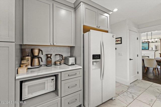 kitchen with tasteful backsplash, white appliances, and gray cabinets