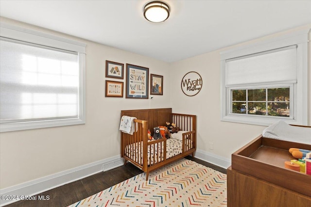 bedroom featuring a nursery area and hardwood / wood-style flooring