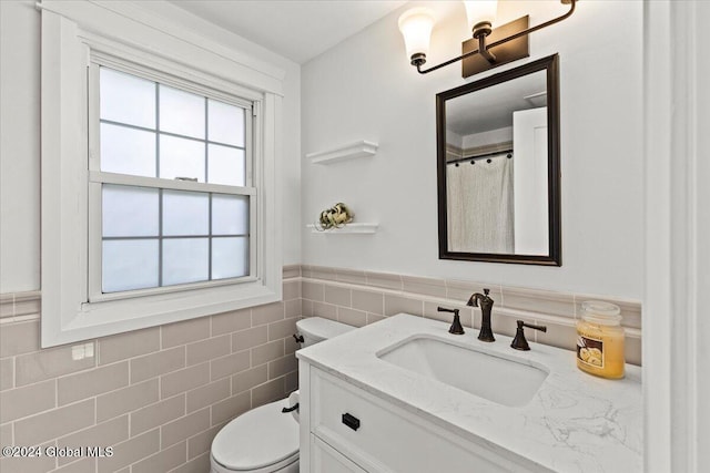 bathroom featuring tile walls, toilet, and vanity