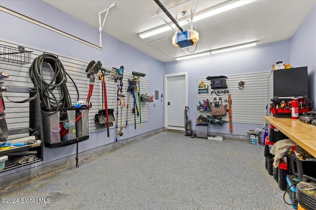 garage with a workshop area and a garage door opener