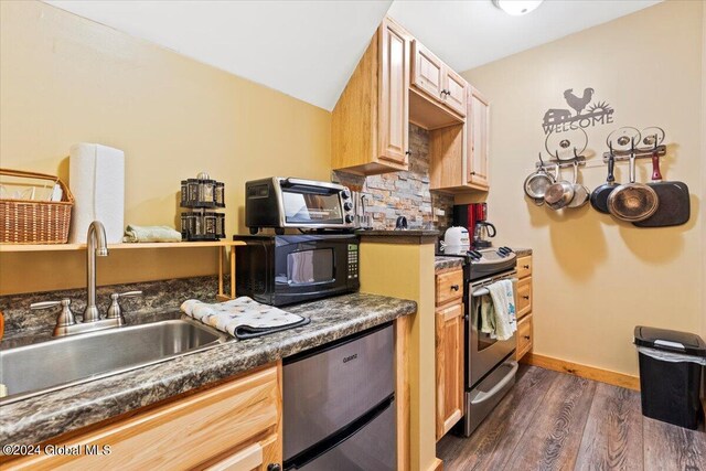 kitchen featuring lofted ceiling, sink, dark hardwood / wood-style floors, appliances with stainless steel finishes, and light brown cabinetry