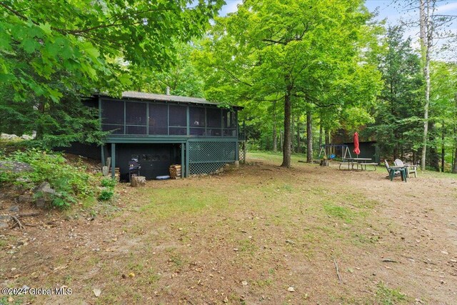 view of yard featuring a playground and a sunroom