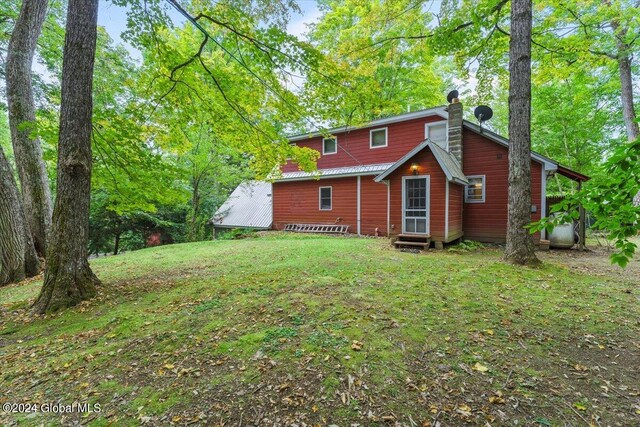 rear view of house featuring a lawn