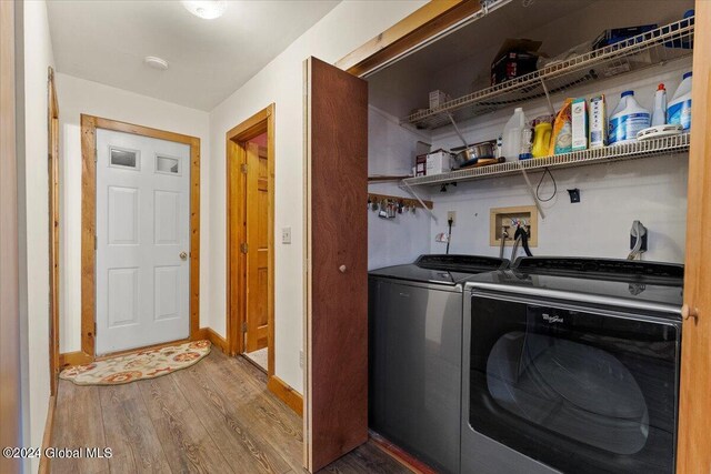 laundry room featuring wood-type flooring and washing machine and dryer