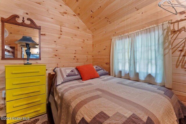 bedroom with wooden walls and vaulted ceiling