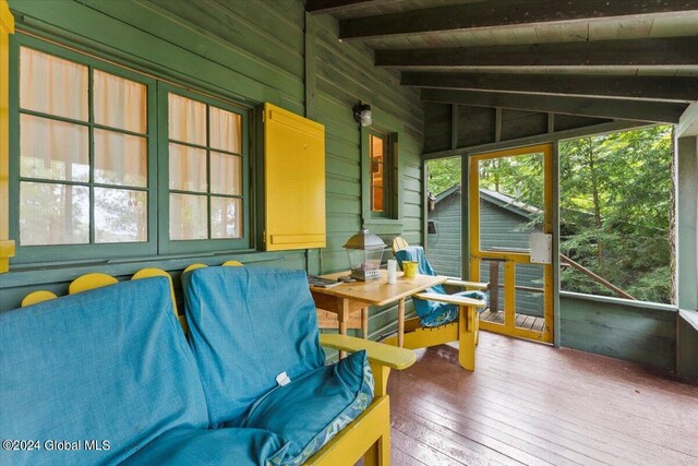 sunroom / solarium featuring lofted ceiling with beams