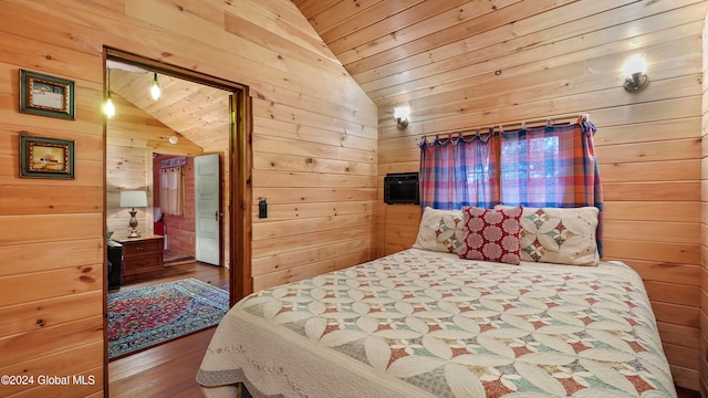 bedroom with wood-type flooring, wooden walls, and lofted ceiling