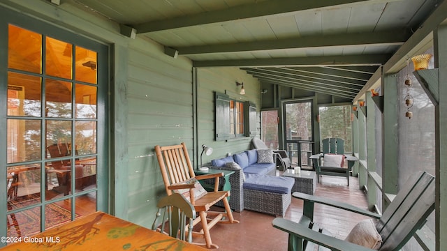 unfurnished sunroom with vaulted ceiling with beams