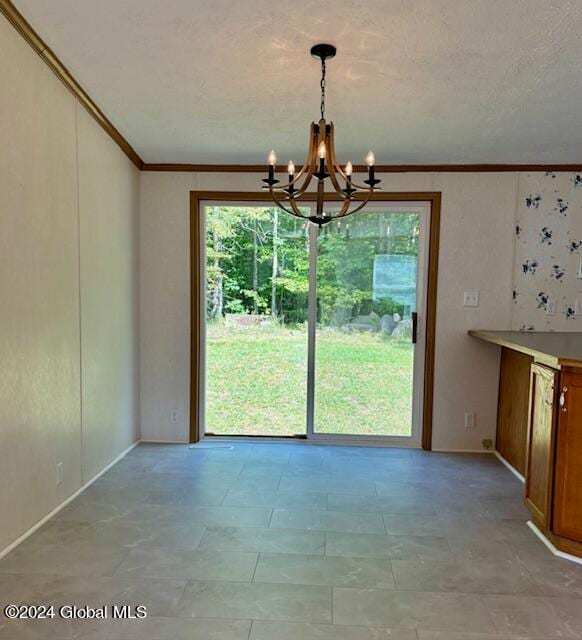 unfurnished dining area featuring ornamental molding and a chandelier