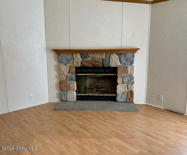 details with a stone fireplace and hardwood / wood-style flooring