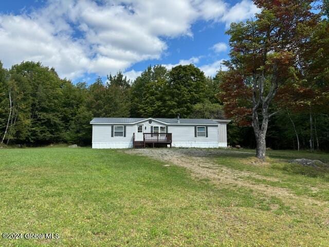 manufactured / mobile home featuring a deck and a front lawn