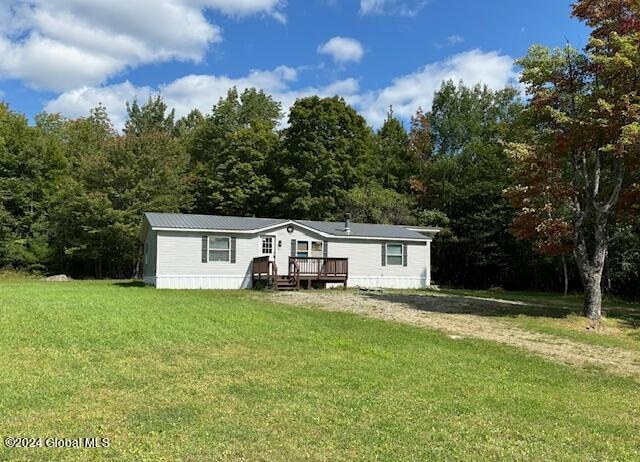 manufactured / mobile home with a deck and a front lawn