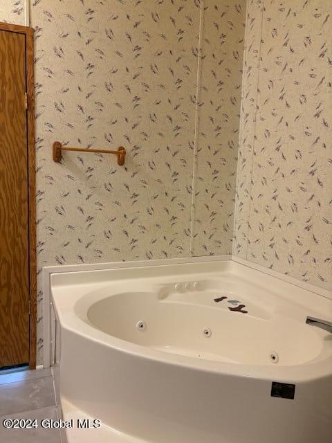 bathroom with a bath and tile patterned flooring