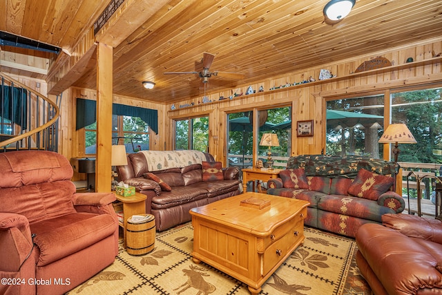 living room with wood ceiling, wooden walls, and ceiling fan