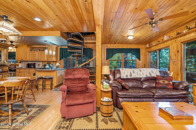 living room with light hardwood / wood-style floors, wooden ceiling, wooden walls, and ceiling fan