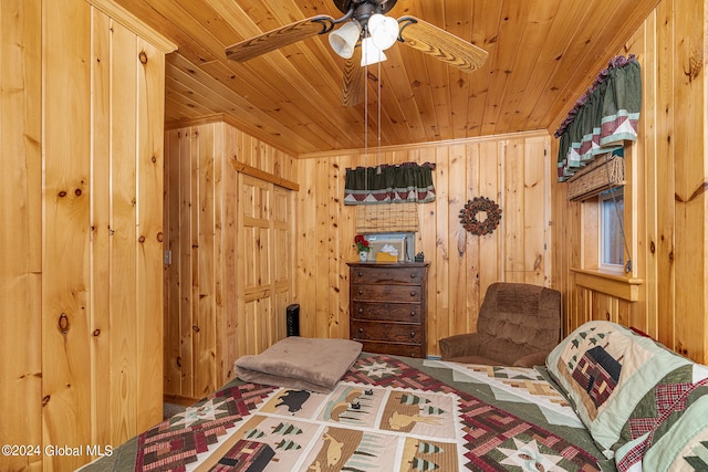 bedroom with ceiling fan, wood walls, and wood ceiling