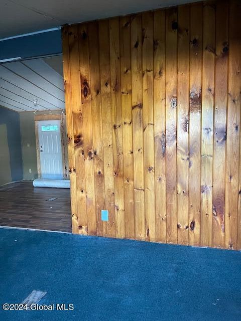 interior space featuring wood-type flooring and wooden walls