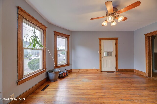 empty room with ceiling fan and light hardwood / wood-style flooring