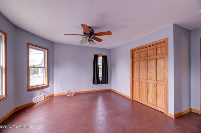 unfurnished bedroom featuring ceiling fan and a closet