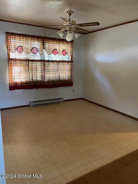 unfurnished room featuring a baseboard heating unit, ceiling fan, and ornamental molding