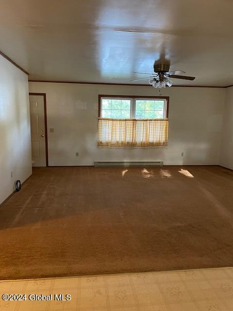 spare room featuring light colored carpet, baseboard heating, and ceiling fan