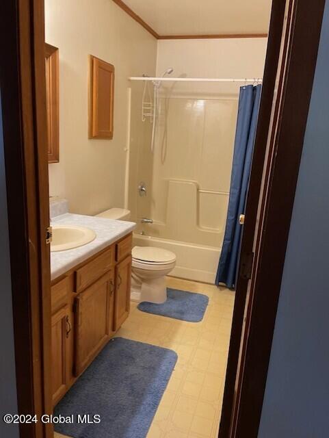 full bathroom with shower / bathtub combination with curtain, toilet, ornamental molding, and vanity