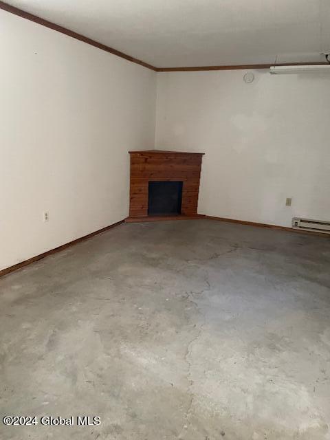 unfurnished living room with concrete flooring, a baseboard radiator, a fireplace, and ornamental molding