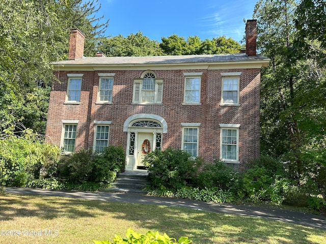 colonial home with a front lawn