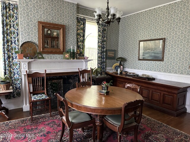 dining area featuring crown molding, dark hardwood / wood-style flooring, and an inviting chandelier