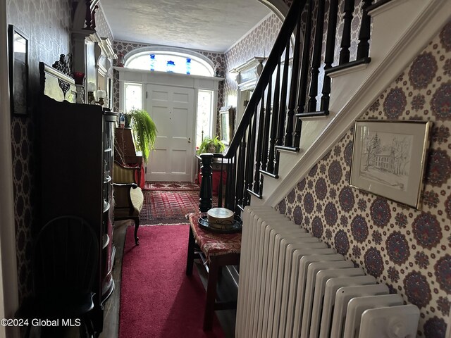 foyer with radiator heating unit and carpet flooring