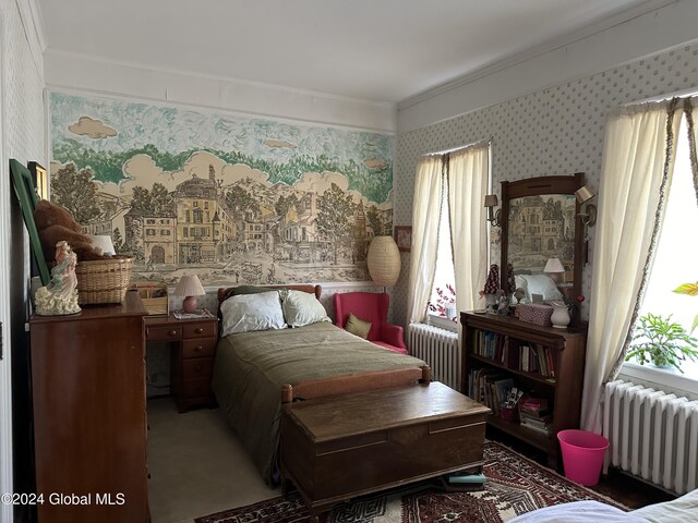 carpeted bedroom featuring crown molding and radiator