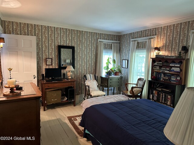 bedroom featuring light wood-type flooring and crown molding