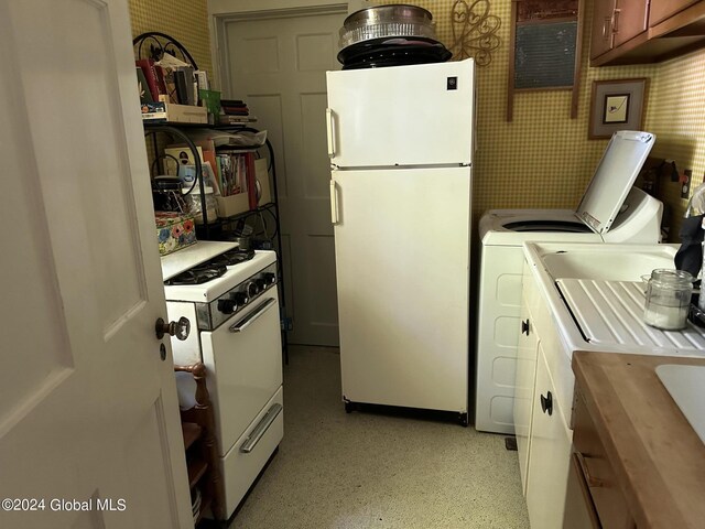 kitchen featuring white appliances and independent washer and dryer