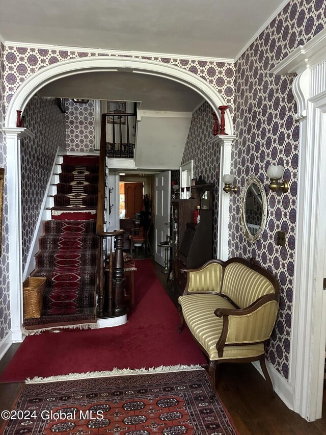 interior space featuring hardwood / wood-style floors, crown molding, and ornate columns