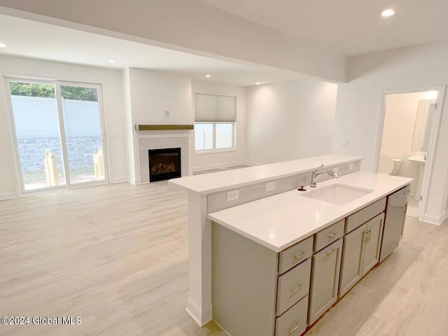 kitchen featuring a center island, light wood-type flooring, sink, and dishwashing machine