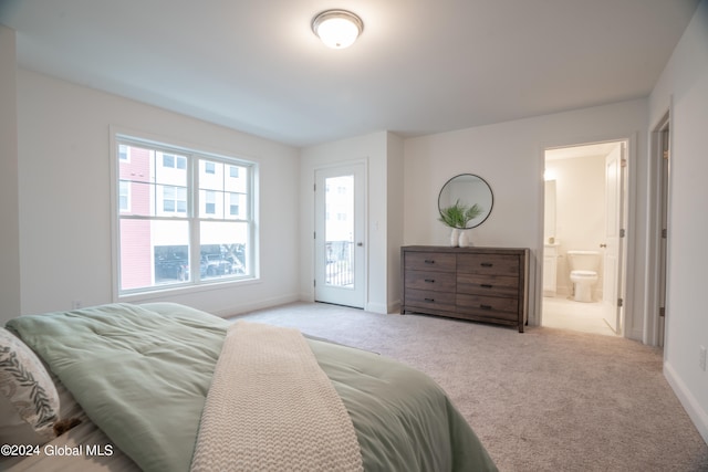 bedroom with ensuite bath, light carpet, and access to exterior