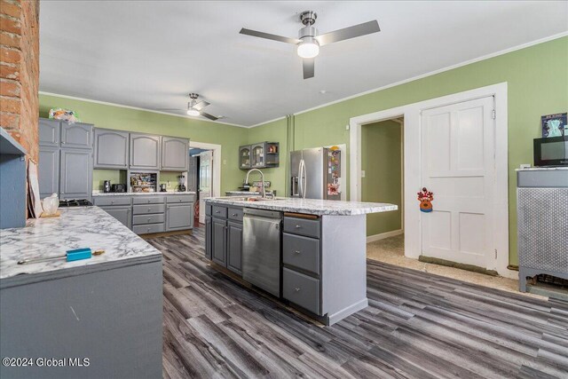 kitchen with stainless steel appliances, crown molding, sink, gray cabinets, and dark hardwood / wood-style floors