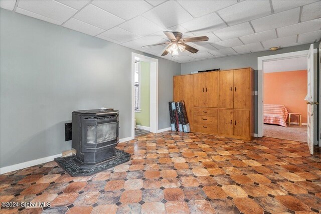 living room featuring a wood stove and ceiling fan