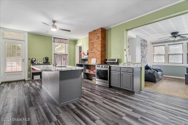 kitchen with ornamental molding, gray cabinetry, dark wood-type flooring, sink, and stainless steel range with gas stovetop