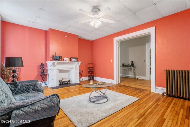 living room with ceiling fan, radiator heating unit, and hardwood / wood-style flooring