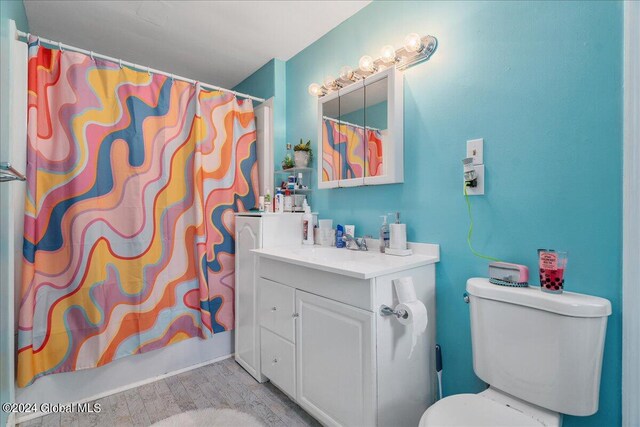 full bathroom with toilet, vanity, shower / tub combo, and hardwood / wood-style flooring