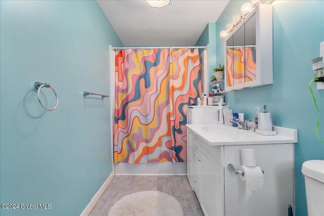 bathroom with vanity, wood-type flooring, and toilet