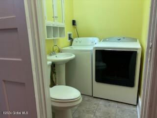 interior space featuring washing machine and clothes dryer and toilet