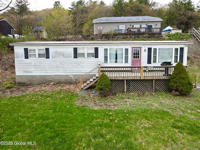 back of house featuring a lawn and a wooden deck